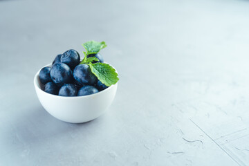 Fresh blueberries in a white bowl. Close up. Copy space for text.