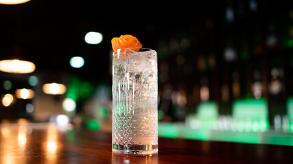 Young guy working as a bartender while preparing cocktails in a pub