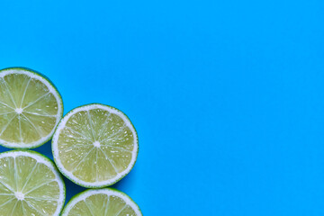 Lime slices on a blue background. CITRUS CITRIC