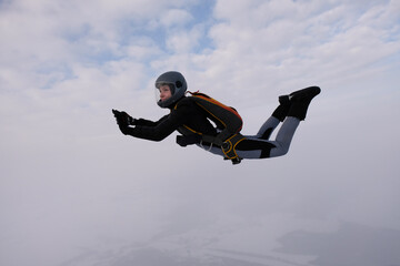 Naklejka na ściany i meble Skydiving. A pretty girl is flying in the sky.