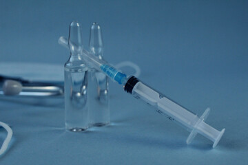 vaccination vaccinated syringe and two vials with lekarts vaccine on a blue blue background with a...
