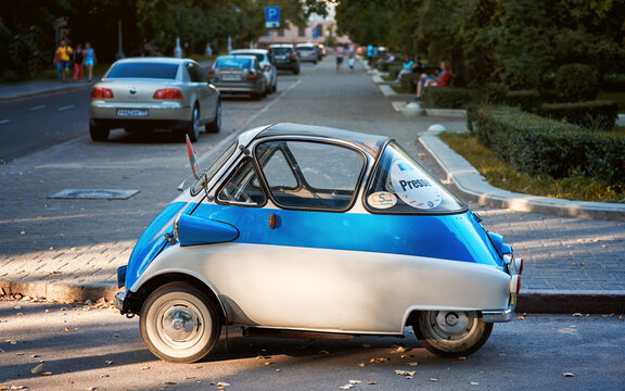 Minsk, Belarus. Aug 2018. BMW Isetta microcar was built in 1955 - small car on the streets of Minsk city. Couple of travelers from Austria traveling by rare vehicle bicolor - blue and creamy white