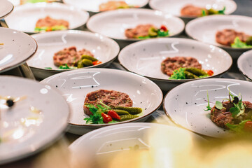 beef tartar with baked toast and egg and cucumbers on a buffet