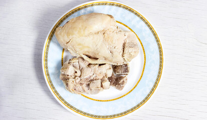 Pieces of boiled meat on a plate. Chicken fillet and pork.