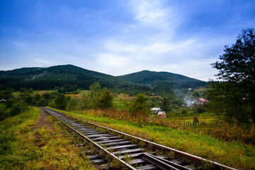 Fototapeta na wymiar Railway in the mountains scenic views tourist route green landscape fluffy forest settlements Carpathians