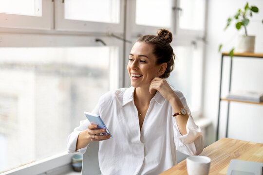 Creative Business Woman Using Smartphone In Loft Office
