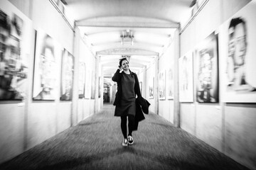 girl walking through a tunnel smiling, black and white
