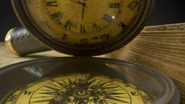 The moving arrow of the old pocket compass with the clock on the top part