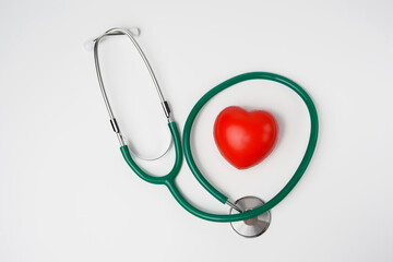 medical stethoscope and red rubber heart on white background