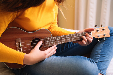 Close-up hands playing ukulele