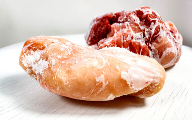 Frozen raw meat, pork and chicken fillet, covered with frost on a white background. Frozen blanks.