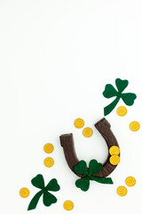 Composition for St. Patrick's Day. Decorating paper with green clover or shamrocks, gold coins and horseshoe.