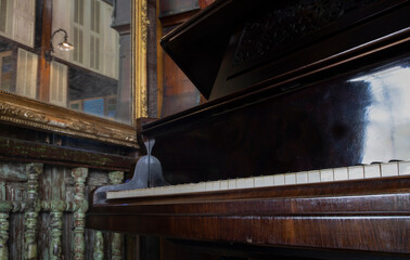 Fototapeta na wymiar An old piano forte by a mirror.
