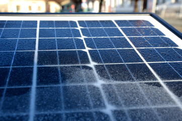 black solar panel frozen by hoarfrost on the street. used to charge the device parking meter,...