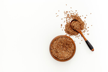 Flax seeds in a spoon and bowl with a bottle of flaxseed oil