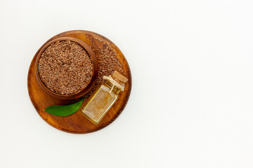 Flax seeds in a spoon and bowl with a bottle of flaxseed oil