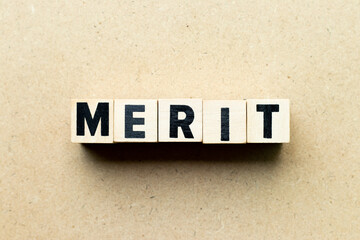 Alphabet letter block in word merit on wood background