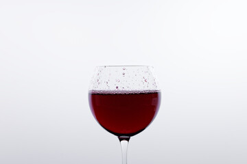 a glass of red wine in front of a white background