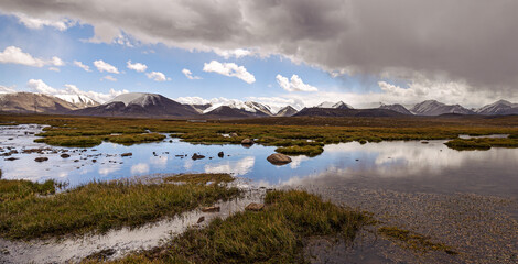 Mountains and clouds reflecting in the water; Kyrgyzstan