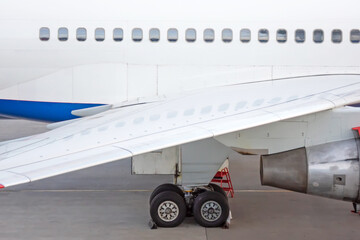 Engine on white fuselage with portholes of passenger plane, jet turbine, windows, wing, aircraft...