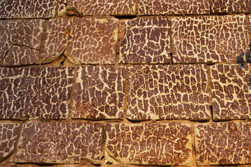 Old destroyed ceramic tiles on the wall of an ancient ruined building. Vintage broken cracked ceramic tile as vintage background for trendy design