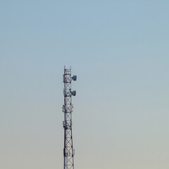 A lonely cell tower on the background of the dirty blue of the sky