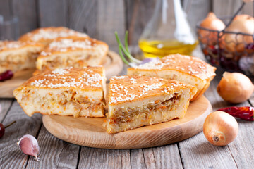 Cabbage pie. Tasty freshly baked homemade vegetable pie with cabbage and sesame seeds on a board