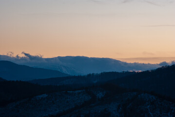 Silhouette of hills and forest at sunset
