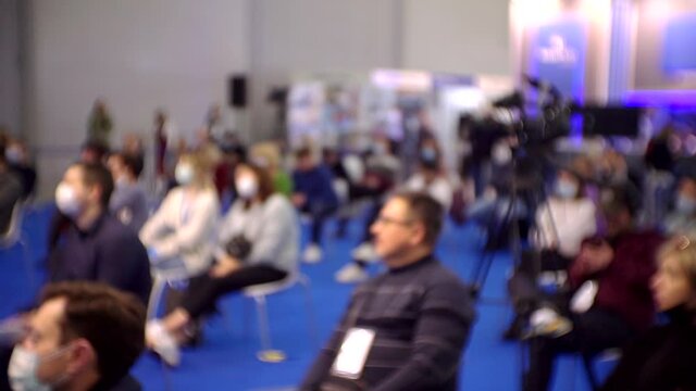 blurred background. People in the large hall at a business presentation.