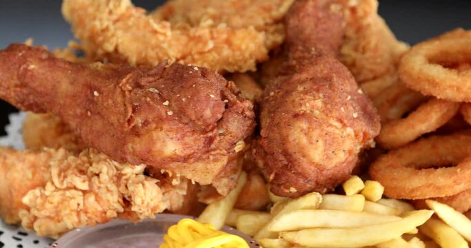 Macro view of Tasty french fries and crispy chicken nuggets with mustard and ketchup at black background