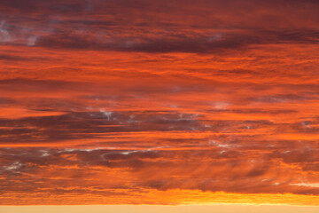 Sunrise, sunset orange yellow pink red sky with clouds background texture