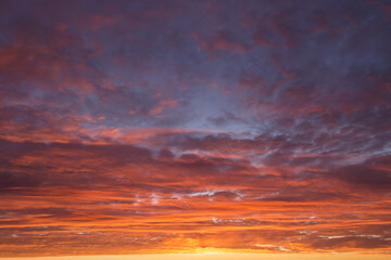 Epic Dramatic  sunrise, sunset orange red yellow pink clouds against blue sky background texture