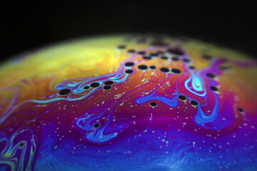 Macro picture of half soap bubble on black ground look like abstract psychedelic color planet in space	