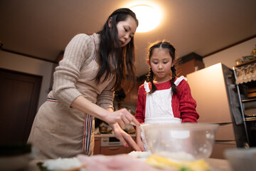 Obraz na płótnie Canvas 巻き寿司を作る母と娘