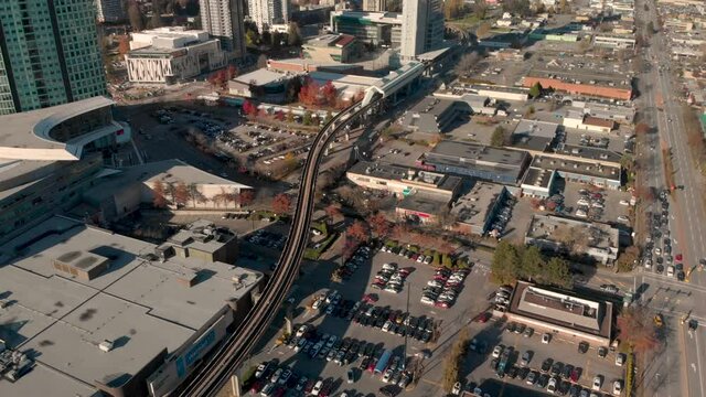 Drone 4K Footage Above Surrey cityscape with highrise buildings train track roads and parking lots with traffic congestion and pollution