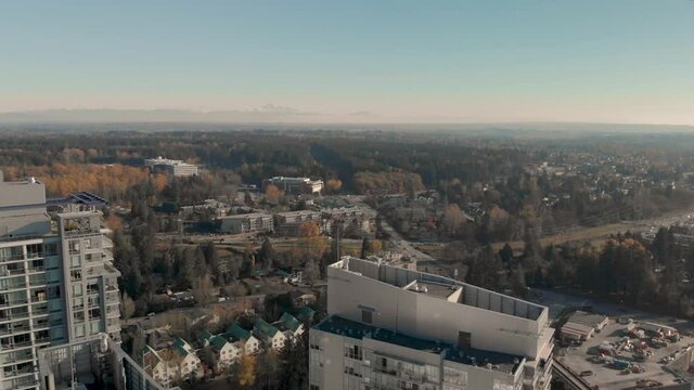 Drone 4K Footage Above Surrey cityscape with highrise buildings train track roads and parking lots with traffic congestion and pollution
