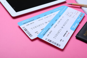 Tickets, passport and tablet on pink background. Travel agency concept