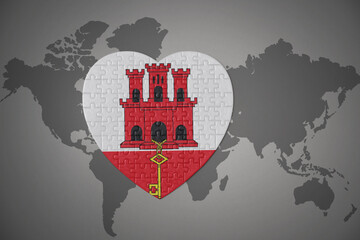 puzzle heart with the national flag of gibraltar on a world map background.