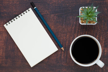 Obraz na płótnie Canvas Top view of open school notebook with blank pages, coffee cup and pencil for taking write notes on table background. Flat lay, creative workspace office. Business-education concept with copy space.