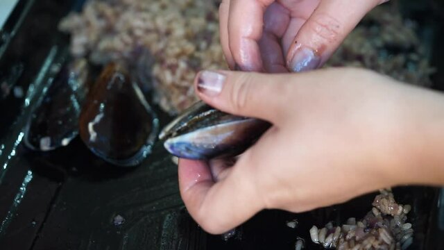 preparing stuffed mussels. oysters, mussels stuffed delicious seafood. it is made by filling the inside of the mussel with Spicy Rice after cooking