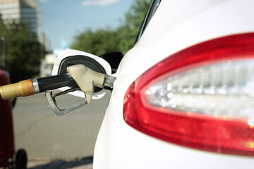 Refueling modern car with petrol pump on gas station, closeup