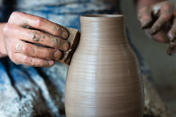 Potter hands making in clay on pottery wheel. Potter makes on the pottery wheel