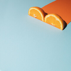 Modern idea with  fresh fruit shaping orange color on bright blue background. Creative geometric concept.