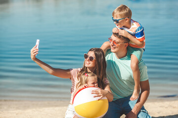 Happy family on the beach. Family vacation. People making selfie on cell phone