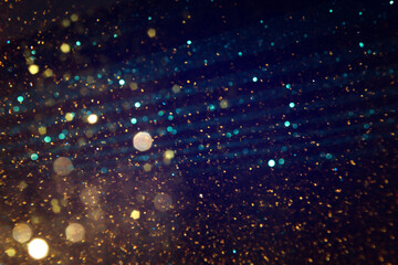 background of abstract blue, gold and black glitter lights. defocused
