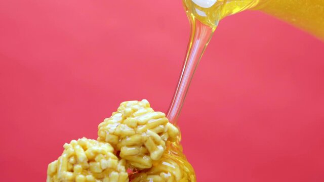 Pouring fresh honey on Tatar sweets chack-chack on pink