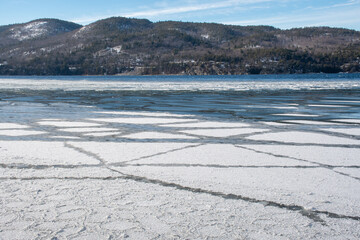 Large pieces of ice with geometric shapes on the surface of a lake in winter