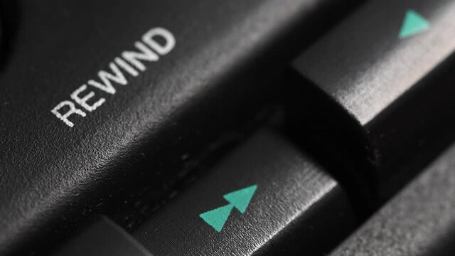 Pressing a button on a vintage tape recorder. Close-up. A person's finger presses the playback control buttons on an audio cassette player. Macro. rewind button