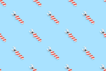 Adjustable wrench seamless pattern. Background made of a metal adjustable wrench with a rubber striped handle. 