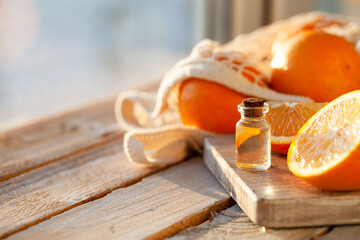 Concept of natural organic orange essential oil for skin face and body care. Moisturizing, aromatherapy, detox treatment, anti-stress effect. White wooden background, copy space for text, close up